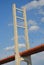 The vertical pylon and diagonal struts of a bridge against a blue sky