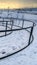 Vertical Rope climbing frame and curving pathway with handrails on a park in winter