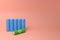 vertical row of 18650 lithium batteries in blue and a green one with the recycling symbol. 3d Render