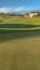 Vertical Scenic view of houses around a golf course under blue sky on a sunny day