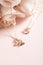 Vertical selective focus closeup of gold necklaces on a rosy pink background