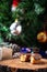 Vertical selective focus shot of half bitten doughnut with a decorated Christmas tree in background