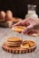 Vertical selective focus shot of a male holding a piece of a biscuit with ingredients on the side