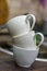 Vertical selective focus shot of a pile of three white tea cups