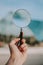 Vertical selective shot of a person holding a clear magnifying glass