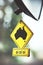 Vertical shallow focus closeup shot of a car rearview mirror charm of a road the map of Australia
