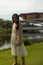 Vertical shallow focus shot of a barefoot Asian female wearing a white dress on the streets