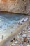 Vertical shoot of people enjoying the beach with array of sunbeds at sunset time