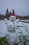 Vertical shot of an adorable snowman on the snowy ground in front of the  Holsten Gate in Lbeck