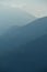 Vertical shot of the Alpine Como Mountains covered with fog