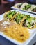 Vertical shot of appetizing Tacos served with a sauce and rice on a white plate