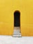 Vertical shot of an arch doorway of a building with bright yellow exterior walls