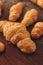 Vertical shot of an array of freshly baked, buttery croissants on a wooden table