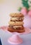 Vertical shot of an assortment of freshly baked cookies displayed on a vibrant pink cake stand