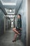 Vertical shot of an attractive female posing in a nice dress in a beautiful hallway
