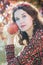 Vertical shot of autumn girl in fall wreath with big ripe apple fruit