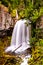 Vertical shot of a babbling waterfall in rocks