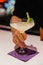 Vertical shot of a barman serving a nice cocktail on a purple napkin