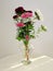 Vertical shot of a beautiful bouquet of asters in a glass vase, placed on a white table