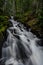 Vertical shot of a beautiful cascading waterfall in the middle of a forest