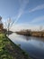 Vertical shot of a beautiful cloudscape over a calm reflective flowing river in Emden, Germany