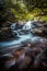 Vertical shot of a beautiful flowing cascade waterfall