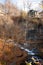 Vertical shot of beautiful houses on top of a hill with a river flowing under