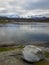 Vertical shot of a beautiful landscape of a shore with misty mountains on the background in Norway