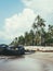 Vertical shot of a beautiful tropical beach with palms polluted with tires and garbage