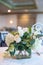 Vertical shot of beautiful white flowers in a vase on a table in a wedding hall