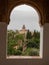 Vertical shot of a beautiful window with the ancient Arabian palace Alhambra view in Granada, Spain