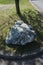 Vertical shot of a big piece of stone in a street lawn