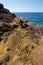 Vertical shot of big rocks in the open sea with a clear blue sky