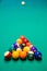 Vertical shot of billiard balls in a triangle shape on the table under the lights