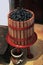 Vertical shot of black grapes in a wooden wine squeezer