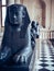 Vertical shot of a black Sphinx sculpture in the Louvre Museum