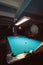 Vertical shot of a blue billiard table under lights