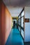 Vertical shot of a blue hallway with colorful walls and windows