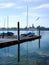 Vertical shot of a boardwalk with ducked boats at Lake Constance with the Konstanz cityscape