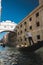 Vertical shot of a boat on the canal below the bridge of sighs in Italy