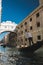 Vertical shot of a boat on the canal below the bridge of sighs in Italy