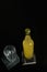 Vertical shot of a bottle of orange juice, lemonade, alcoholic beverage and an empty glass standing on black wooden table