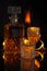 Vertical shot of a bottle of whiskey and glasses with flames on a black background