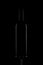Vertical shot of a bottle of wine and the bottom part of a wine glass on a black background