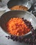 Vertical shot of a bowl of shredded carrots, cinnamon, and flour, for making carrot cookies