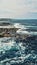 Vertical shot of the breathtaking view of a wavy bay surrounded by cliffs captured on a sunny day