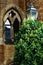 Vertical shot of a brick building and a window close to a tree and a streetlamp