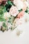 Vertical shot of a bridal bouquet of roses on a white surface