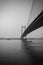 Vertical shot of a bridge James Prinsep Ghat in grayscale in Kolkata, India