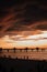 Vertical shot of a bright orane sunset sky over the pier of Baltic Sea